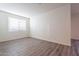 Bright and airy bedroom with wood-look flooring and large window at 24144 W Gibson Ln, Buckeye, AZ 85326