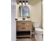 Updated bathroom featuring a wooden vanity with black hardware, a modern sink, and a sleek, arched mirror at 2500 N Hayden Rd # 19, Scottsdale, AZ 85257