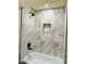 Close-up of a modern shower featuring marble-look tiling, black hardware, and a convenient built-in niche at 2500 N Hayden Rd # 19, Scottsdale, AZ 85257