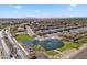 Aerial view of the community showcasing homes surrounding a pond and green spaces, creating a harmonious living environment at 37730 W Padilla St, Maricopa, AZ 85138