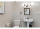 Charming bathroom featuring a pedestal sink, framed mirror, and modern bronze fixtures at 4035 E Indianola Ave, Phoenix, AZ 85018