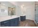 Bright bathroom featuring double vanity, wood-look tile floor, and a large tiled shower at 44713 N 44Th Dr, Phoenix, AZ 85087