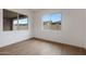 Bright bedroom with wood-look tile flooring and two windows providing natural light at 44713 N 44Th Dr, Phoenix, AZ 85087