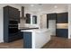 Contemporary kitchen featuring dark cabinets, white countertops, a spacious island, and stainless steel appliances at 44713 N 44Th Dr, Phoenix, AZ 85087