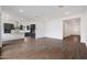 Spacious living area featuring wood-look tile flooring, neutral walls, and an open view of the kitchen at 44713 N 44Th Dr, Phoenix, AZ 85087