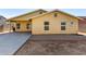 Home's back exterior with covered patio and gravel yard at 12640 W Florence St, Avondale, AZ 85323