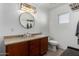 Clean bathroom with vanity, toilet, and large round mirror above the sink at 12640 W Florence St, Avondale, AZ 85323