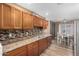 Well-equipped kitchen with wood cabinets, tile backsplash, and tile flooring at 12640 W Florence St, Avondale, AZ 85323