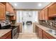 Open kitchen with view to living room, stainless steel appliances, and tile floor at 12640 W Florence St, Avondale, AZ 85323