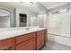 Bathroom with wood cabinets, a bathtub, and a shower at 15829 W Carmen Dr, Surprise, AZ 85374