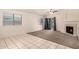 Bright living room with vaulted ceiling, fireplace, tile and carpet flooring, and slider to backyard at 1778 S Saddle St, Gilbert, AZ 85233