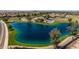 Aerial view of a community lake and park with basketball court at 35907 W San Clemente Ave, Maricopa, AZ 85138