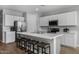 Modern kitchen with white cabinets, a large island, and stainless steel appliances at 35907 W San Clemente Ave, Maricopa, AZ 85138