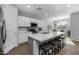 Modern kitchen with white cabinets, island with seating, and stainless steel appliances at 35907 W San Clemente Ave, Maricopa, AZ 85138