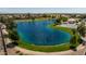 Drone view of a community lake and park with a basketball court and gazebo at 35907 W San Clemente Ave, Maricopa, AZ 85138