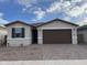 Charming single-story home featuring a two-car garage and low maintenance desert landscaping at 39995 W Elm Dr, Maricopa, AZ 85138