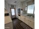 Kitchen with white cabinets, double sink, and door leading to outside at 7300 N 51St Ave # E78, Glendale, AZ 85301