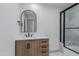 Modern bathroom features a wood vanity, black hardware, and a glass-enclosed shower at 7955 E Chaparral Rd # 103, Scottsdale, AZ 85250