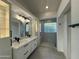 Modern bathroom with double vanity, large mirrors, and glass block shower at 8050 E Tuckey Ln, Scottsdale, AZ 85250