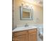 Bright bathroom with a wood vanity cabinet, a framed mirror and decorative lighting fixture and ceramic tile at 524 S Allred Dr, Tempe, AZ 85288