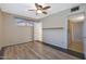 Spacious bedroom with ceiling fan, wood-look flooring, and access to bathroom at 2101 W Palmaire Ave, Phoenix, AZ 85021