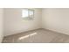 A light-filled bedroom with a window, carpet, and neutral walls at 2848 N Evergreen St, Buckeye, AZ 85396