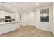 Well-lit open space connects modern kitchen and living area with a bright window and white door at 2848 N Evergreen St, Buckeye, AZ 85396