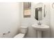 Cozy powder room with pedestal sink, toilet, and small window providing natural light at 2848 N Evergreen St, Buckeye, AZ 85396