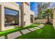 Backyard featuring artificial turf, stone pavers, modern architectural details, and a desert landscape at 629 E Myrtle Ave, Phoenix, AZ 85020