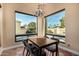 Cozy dining room with a chandelier, large windows showcasing the backyard, and tile floors at 629 E Myrtle Ave, Phoenix, AZ 85020