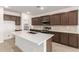 Modern kitchen with dark cabinets, an island, and tile flooring at 7280 E White Tail Rd, San Tan Valley, AZ 85143