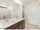 Bathroom with double vanity, large mirror, and glass shower enclosure at 16032 W Desert Hollow Dr, Surprise, AZ 85387