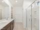 Spa-like bathroom with double sinks and glass-enclosed shower at 16032 W Desert Hollow Dr, Surprise, AZ 85387