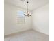 A simple dining room offers lots of natural light and a contemporary chandelier at 16032 W Desert Hollow Dr, Surprise, AZ 85387