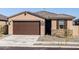 Charming single-story home with a two-car garage, stone accents and low maintenance desert landscaping at 16032 W Desert Hollow Dr, Surprise, AZ 85387