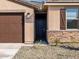 Close up of a home's entrance with a dark brown front door and stone veneer accents at 16032 W Desert Hollow Dr, Surprise, AZ 85387