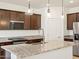 Modern kitchen featuring stainless steel appliances, granite countertops, and pendant lighting at 16032 W Desert Hollow Dr, Surprise, AZ 85387