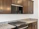 Close up view of kitchen details featuring a gas range and granite countertops at 16032 W Desert Hollow Dr, Surprise, AZ 85387