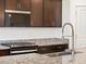 Close up view of kitchen details featuring a stainless steel faucet and granite countertops at 16032 W Desert Hollow Dr, Surprise, AZ 85387