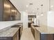 Open kitchen with dark wood cabinets, granite countertops, stainless steel appliances, and tile floors at 16032 W Desert Hollow Dr, Surprise, AZ 85387