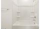 Clean, modern shower over tub features a sleek white surround with built-in shelves at 16032 W Desert Hollow Dr, Surprise, AZ 85387