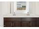 Bathroom vanity with dual sinks, dark wood cabinets and chrome hardware at 16066 W Prickly Pear Trl, Surprise, AZ 85387