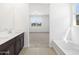 Bathroom showcasing double vanity and view to bedroom with natural light at 16066 W Prickly Pear Trl, Surprise, AZ 85387