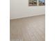 Close up view of wood-look tile floors and white baseboards in a bedroom at 16066 W Prickly Pear Trl, Surprise, AZ 85387