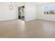 Bright living room with wood-look tile, modern light fixture, and backyard access at 16066 W Prickly Pear Trl, Surprise, AZ 85387