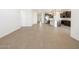Large living room leading to a kitchen area, featuring light wood-look tile flooring at 16066 W Prickly Pear Trl, Surprise, AZ 85387