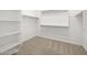 Walk-in closet with white shelving and neutral carpet at 16066 W Prickly Pear Trl, Surprise, AZ 85387