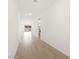 Bright hallway with wood-look flooring, white walls, and a view to the backyard at 16072 W Prickly Pear Trl, Surprise, AZ 85387