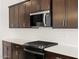 Stylish kitchen with stainless steel appliances, white quartz countertops, and dark wood cabinetry at 16072 W Prickly Pear Trl, Surprise, AZ 85387