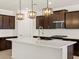Modern kitchen with a large island, stainless steel appliances, dark cabinets, and white countertops at 16072 W Prickly Pear Trl, Surprise, AZ 85387